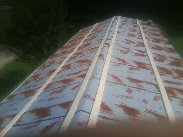 Rusted metal roof panels with new wood purlins before replacement — Storm Damage Roof Repair in Kew Gardens by Roofing Brothers