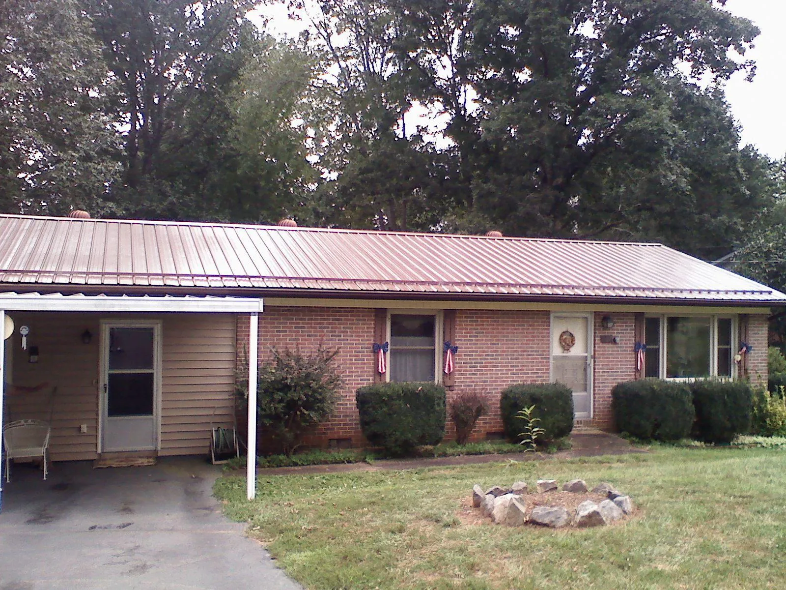 Bronze metal roof and carport on a brick ranch home — Roof Repair work by our crew in Kew Gardens